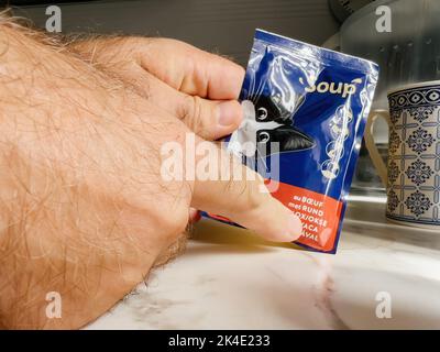 Paris, France - 13 septembre 2022: Sac de main mâle POV avec Felix Wet chat food goût de boeuf - cuisine moderne fond se préparant à nourrir l'animal de chat Banque D'Images