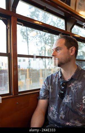 Un homme assis dans un célèbre tramway historique de la classe W de Melbourne, en regardant par la fenêtre Banque D'Images