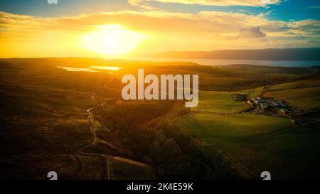 Une vue aérienne de la rivière Clyde qui traverse les montagnes en Écosse au coucher du soleil Banque D'Images