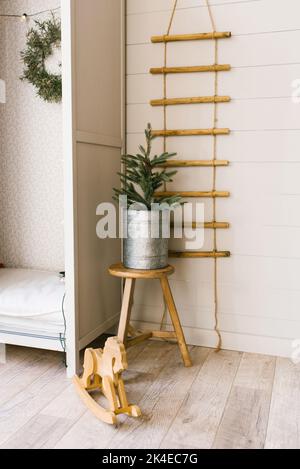 Arbre de Noël dans une marmite en fer près du placard dans la chambre des enfants Banque D'Images