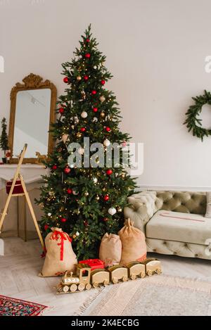 Magnifique sapin de Noël élégant avec cadeaux dans le salon Banque D'Images