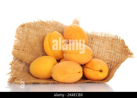 Plusieurs abricots juteux d'ananas avec une serviette en jute, gros plan, sur fond blanc. Banque D'Images