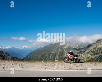 Une moto d'aventure avec est garée à un col de montagne dans les alpes suisses. Banque D'Images