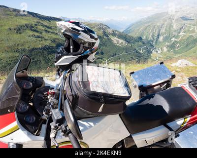 Sac-citerne avec carte sur une moto d'aventure à un col de montagne dans les alpes suisses. Banque D'Images