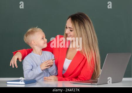 Mère et fils ensemble à l'aide d'un ordinateur portable. École éducation d'apprentissage d'enfant leçon en ligne. L'enseignant aide les élèves à apprendre la leçon. Banque D'Images