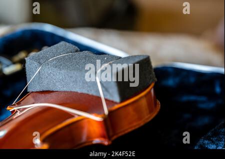 Accent sélectif sur un coussin en mousse utilisé comme repose-épaules pour un violon jeune. La méthode bon marché utilise un élastique pour maintenir en place. Banque D'Images