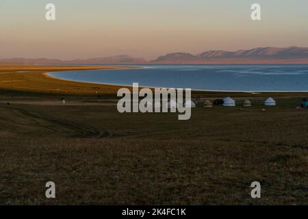 Rive du lac Song Kul avec camp de yourt et montagnes environnantes au coucher du soleil de l'heure d'or, Kirghizistan Banque D'Images