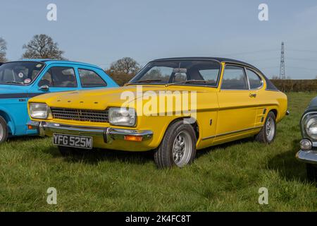 Vue à 3/4 angles d'un Ford Capri XL jaune vif de 1973 1600 garé sur l'herbe à une rencontre d'un club de voiture classique Banque D'Images