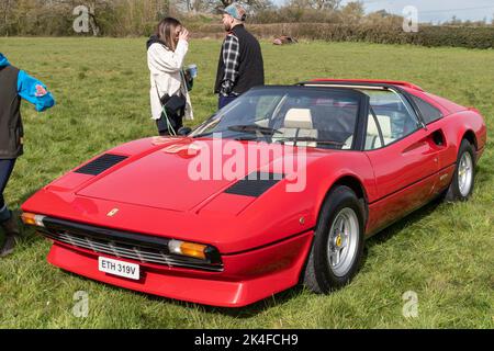 Une vue avant à 3/4 angles d'une Ferrari 308 GTS 1980 avec le panneau de toit déposé , garée sur l'herbe à une rencontre d'un club de voiture classique Banque D'Images