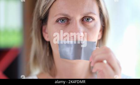 Belle femme avec bande de conduit sur la bouche près Banque D'Images