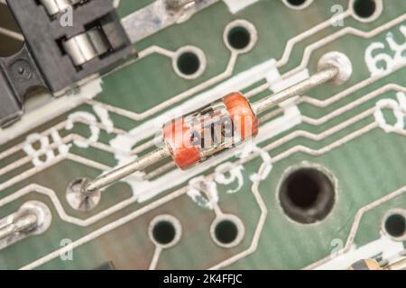 Carte de circuit imprimé à montage traversant de style ancien avec condensateur en verre. Pour la production électronique pré-CMS / montage en surface. Ceci se trouve sur un ancien circuit imprimé du spectre 1982 Sinclair ZX. Banque D'Images