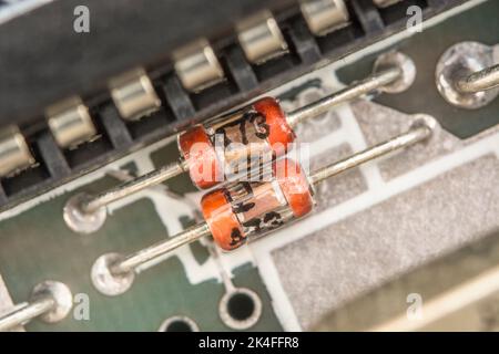 Carte de circuit imprimé à montage traversant de style ancien avec condensateur en verre. Pour la production électronique pré-CMS / montage en surface. Ceci se trouve sur un ancien circuit imprimé du spectre 1982 Sinclair ZX. Banque D'Images