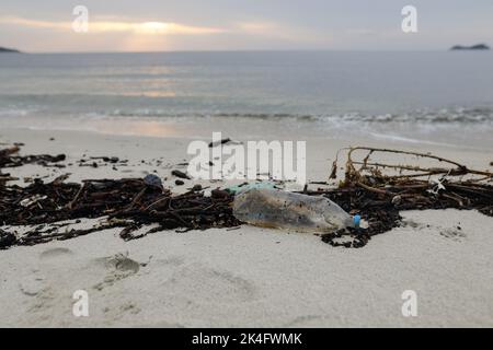 Les déchets de plastique et de bois ont été lavés à terre sur la plage d'or de Thassos après une tempête puissante le matin d'été nuageux. Banque D'Images