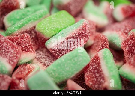 Bonbons gélifiés sous forme de pastèques dans le sucre, macro-shot. Banque D'Images
