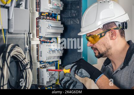 Man, un technicien en électricité travaillant dans un tableau de commutation avec des fusibles. Banque D'Images