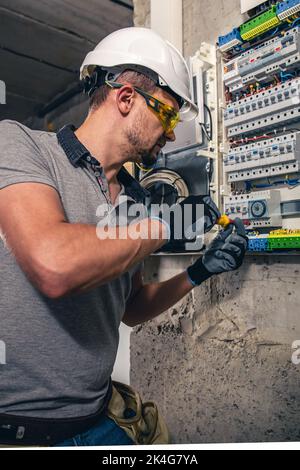 Man, un technicien en électricité travaillant dans un tableau de commutation avec des fusibles. Banque D'Images