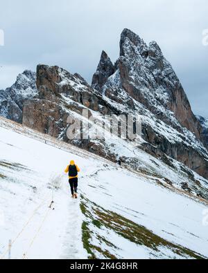 Vue incroyable sur le pic de Seceda couvert de neige avec le brave randonneur touristique sous le pic. Trentin-Haut-Adige, Alpes Dolomites, Tyrol du Sud, Italie, Banque D'Images