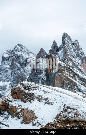 Vue incroyable sur le pic de Seceda couvert de neige avec le brave randonneur touristique sous le pic. Trentin-Haut-Adige, Alpes Dolomites, Tyrol du Sud, Italie, Banque D'Images