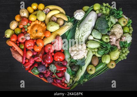 Coeur fait de légumes frais et de fruits sur fond de bois. Banque D'Images