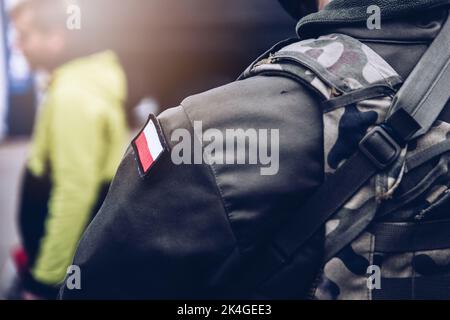 Soldat de l'armée polonaise avec un uniforme de camouflage avec le drapeau polonais sur sa manche. Banque D'Images