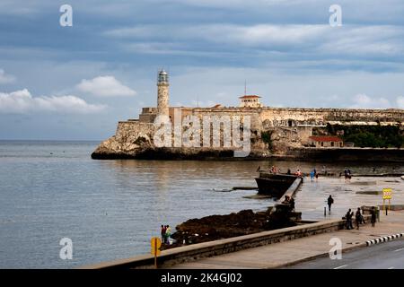 Les Cubains marchent, parlent, se détendent, jouent, nagent, Pêcher et profiter du temps lors d'une journée ensoleillée le long de la Malecón à la Havane, Cuba. Banque D'Images