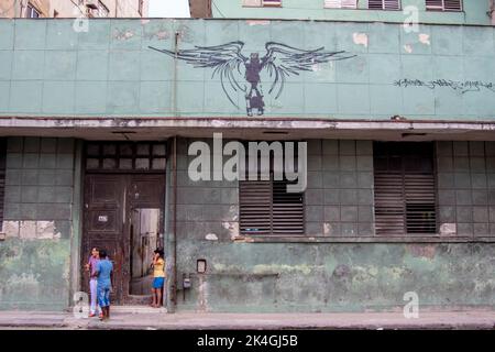 Fresque du président révolutionnaire cubain Fidel Castro sur un bâtiment avec des gens sur le chemin de la main qui parlent à la Habana Cuba. Banque D'Images