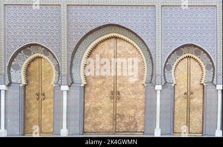 Porte bleue en forme d'arc, carrelée d'arabe, avec trois portes dorées Banque D'Images