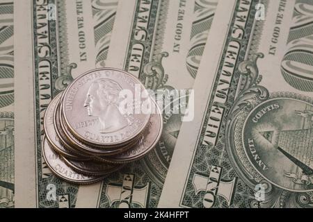 Pile de vingt-cinq cents US en plus des billets d'un dollar. Banque D'Images