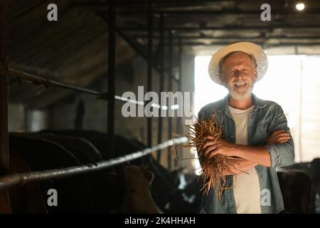 Portrait d'un fermier mature de sexe masculin dans un abri de cowshed Banque D'Images