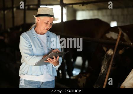 Agricultrice mature travaillant dans le lâcheté Banque D'Images