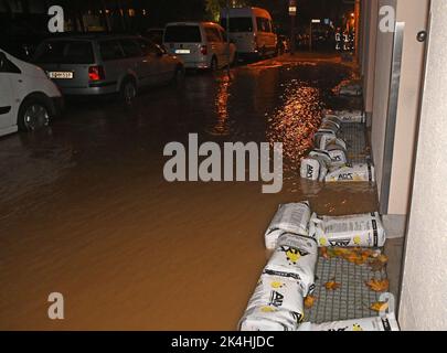 Berlin, Allemagne. 02nd octobre 2022. Des sacs de sable sont utilisés pour protéger les maisons de l'eau dans Gotlindestraße à Lichtenberg. Trois sous-sols et un garage souterrain ont été remplis d'eau dimanche soir après une explosion de pipe à Berlin-Lichtenberg. Pour permettre au service des incendies de pomper l'eau du parking souterrain, l'électricité a dû être coupée dans un bloc complet d'appartements. Credit: Paul Zinken/dpa/Alay Live News Banque D'Images