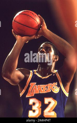 La superstar de la NBA, Ervin 'Magic' Johnson, tire un jeu gratuit pendant l'action contre les Chicago Bulls en 1980s. Banque D'Images