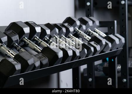 Dumbbbbell maison mur flou gym set de stockage rig sport, pour accessoires équipement de noir pour l'exercice actif, puissance dure. Levage , Banque D'Images