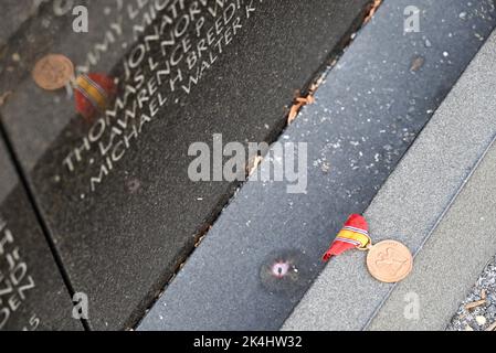 Une médaille du service de la Défense nationale est laissée en hommage à la base du mur commémoratif du Vietnam à Washington, DC. Banque D'Images