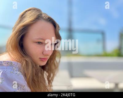 Visage tendre d'une fille avec des taches de rousseur gros-sur elle a les cheveux blonds et les yeux brillants qu'elle regarde et peut être utilisé pour toute publicité il y a un endroit pour le texte. La Tour Eiffel en arrière-plan Banque D'Images