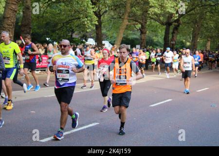 St. James Park & Birdcage Walk, Londres, Royaume-Uni. 10 octobre 2022. Un retinue apparemment sans fin de coureurs à vitesse moyenne et basse descend la dernière étape du marathon de Londres 2022, en descendant la promenade de Birdcage le long de la limite sud du St. James Park de Londres, En route pour tourner autour de l'édifice de devant de Buckingham Palace et sur la ligne d'arrivée située le long d'une célèbre promenade, à savoir le centre commercial de Londres. Crédit : ©Julia Mineeva/EGBN TV News/Alay Live News Banque D'Images