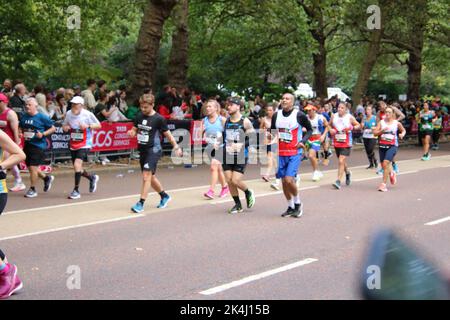 St. James Park & Birdcage Walk, Londres, Royaume-Uni. 10 octobre 2022. Un retinue apparemment sans fin de coureurs à vitesse moyenne et basse descend la dernière étape du marathon de Londres 2022, en descendant la promenade de Birdcage le long de la limite sud du St. James Park de Londres, En route pour tourner autour de l'édifice de devant de Buckingham Palace et sur la ligne d'arrivée située le long d'une célèbre promenade, à savoir le centre commercial de Londres. Crédit : ©Julia Mineeva/EGBN TV News/Alay Live News Banque D'Images