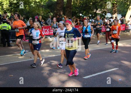 St. James Park & Birdcage Walk, Londres, Royaume-Uni. 10 octobre 2022. Un retinue apparemment sans fin de coureurs à vitesse moyenne et basse descend la dernière étape du marathon de Londres 2022, en descendant la promenade de Birdcage le long de la limite sud du St. James Park de Londres, En route pour tourner autour de l'édifice de devant de Buckingham Palace et sur la ligne d'arrivée située le long d'une célèbre promenade, à savoir le centre commercial de Londres. Crédit : ©Julia Mineeva/EGBN TV News/Alay Live News Banque D'Images