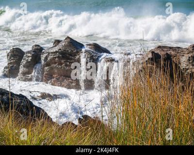 Vagues se brisant autour de la base rocheuse du mont Maunganui Banque D'Images