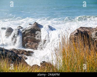 Vagues se brisant autour de la base rocheuse du mont Maunganui Banque D'Images