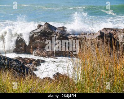 Vagues se brisant autour de la base rocheuse du mont Maunganui Banque D'Images