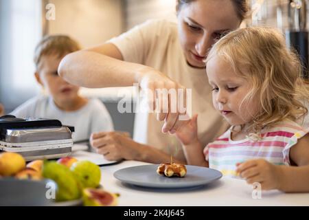 Bonne cuisine familiale avec gaufres à cuire ensemble et petit déjeuner le week-end dans la cuisine maison Banque D'Images