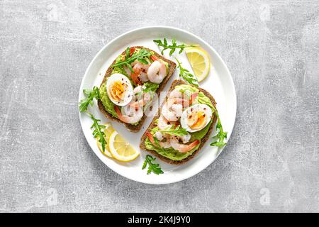 Toast avec crevettes, guacomole d'avocat, arugula et œuf dur, vue du dessus Banque D'Images