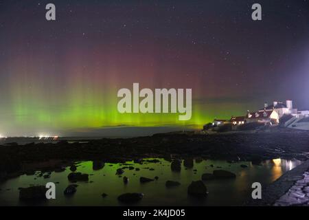 Les aurores boréales, mieux connues sous le nom de lumières nordiques, apparaissent tôt le matin sur l'île St Mary's, dans la baie Whitley, sur le nord de Tyneside. Date de la photo: Lundi 3 octobre 2022. Banque D'Images