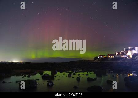 Les aurores boréales, mieux connues sous le nom de lumières nordiques, apparaissent tôt le matin sur l'île St Mary's, dans la baie Whitley, sur le nord de Tyneside. Date de la photo: Lundi 3 octobre 2022. Banque D'Images