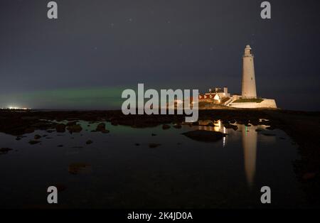 Les aurores boréales, mieux connues sous le nom de lumières nordiques, apparaissent tôt le matin sur l'île St Mary's, dans la baie Whitley, sur le nord de Tyneside. Date de la photo: Lundi 3 octobre 2022. Banque D'Images
