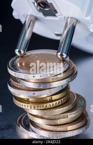 Pile de pièces en euros et prise électrique, concept d'augmentation des prix de l'énergie Banque D'Images
