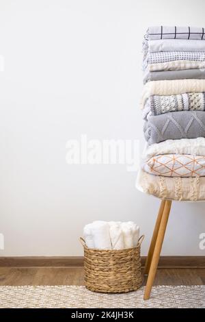 Linge de lit soigneusement plié sur chaise mur blanc minimaliste Nordic appartement parquet et moquette Banque D'Images