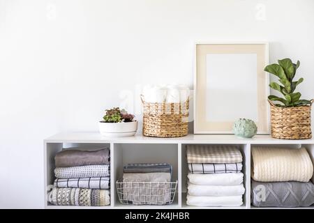 Plantes en pots dans des paniers de paille écologique sur la tablette de linge de lit armoire de rangement textile Banque D'Images