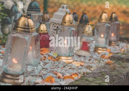 bougies allumées dans les lanternes sur la tombe du cimetière Banque D'Images